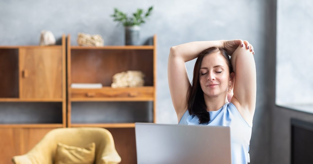 Foto: Frau macht Yoga-Übungen vorm Notebook