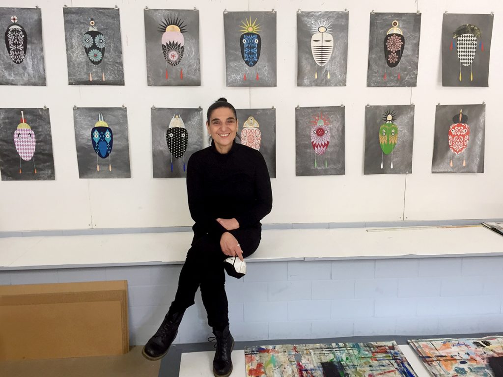 Foto: Cholud Kassem sitzt vor Ihren Arbeiten aus der Serie Weeping Pillows