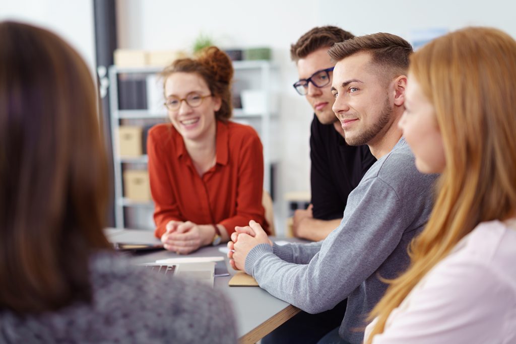 Foto: Junge Menschen besprechen sich im Büro