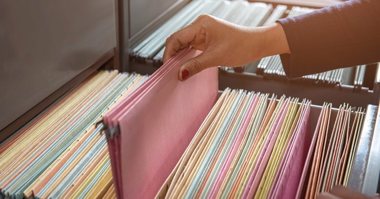 Foto: Hand blätter im Aktenschrank